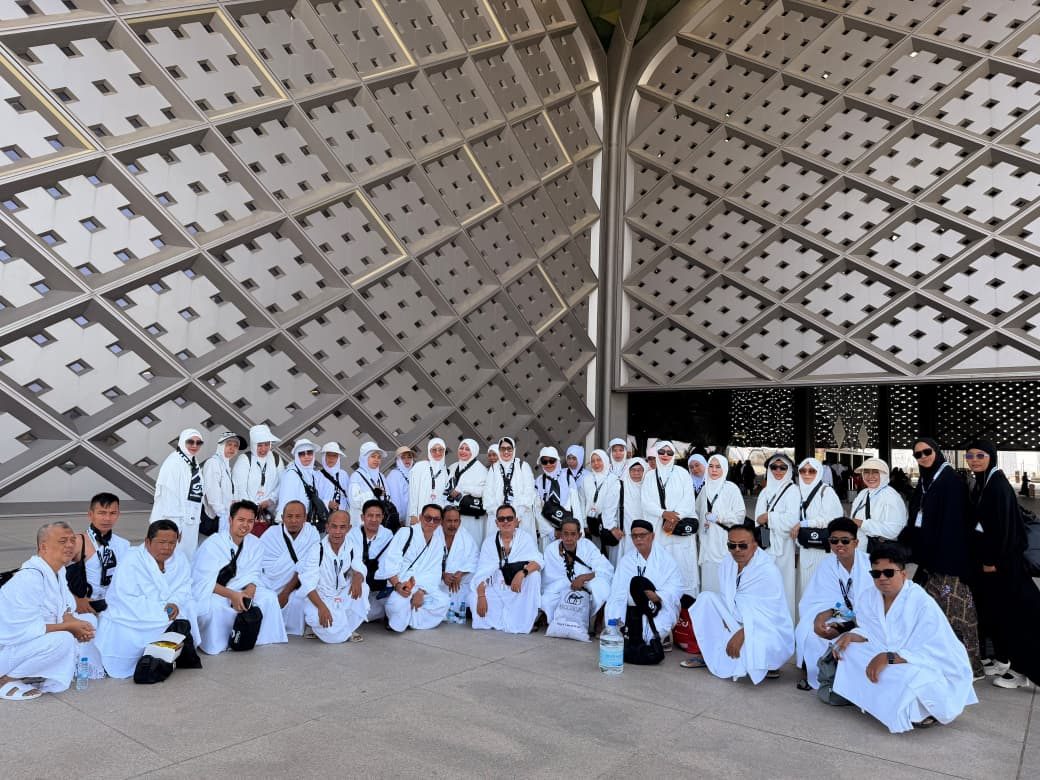 Rombongan jemaah umroh mengenakan kain ihram di bandara